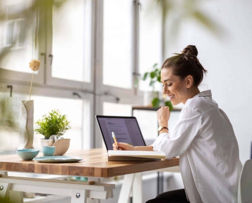 Creative young woman working on laptop in her studio_