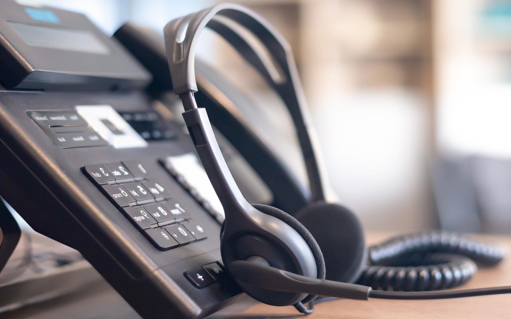 helpdesk phone and headphones on a desk