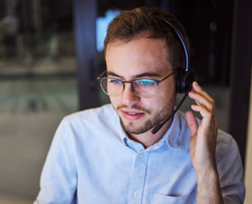 A man working in support with a headset in his office