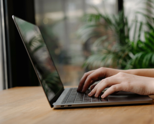 Side view of a woman typing on a laptop