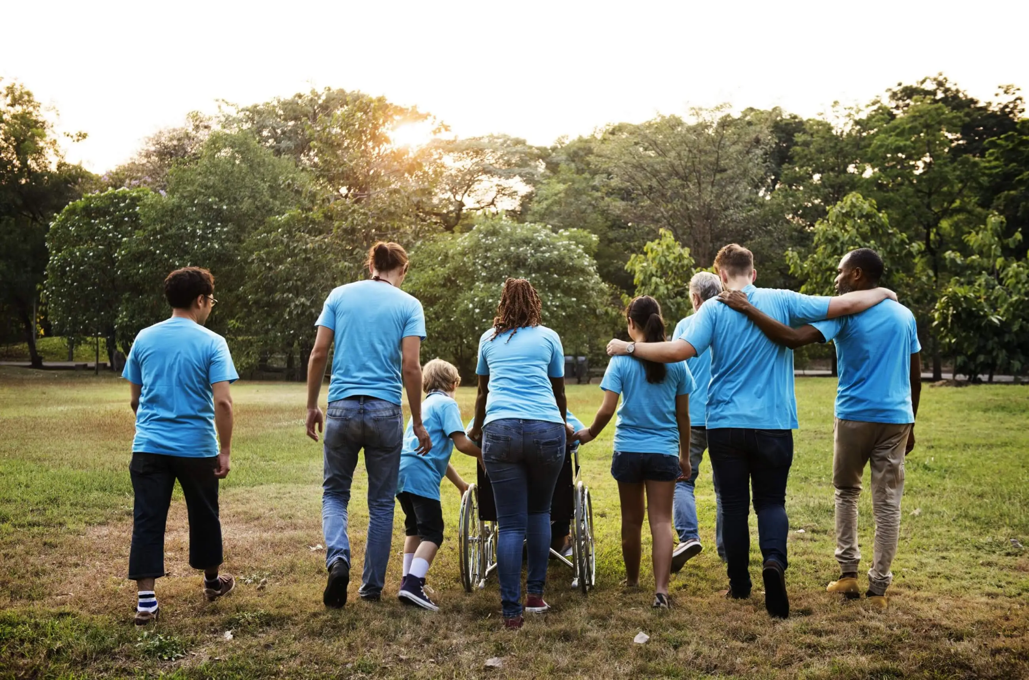 Group of diverse people walking together outdoors in a park.